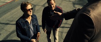 Movie still from “Drive” (2011), directed by Nicolas Winding Refn – A group of men standing next to each other on a street; Medium shot, Over the shoulder angle