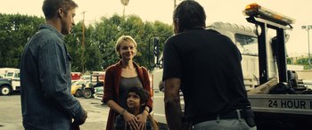 Movie still from “Drive” (2011), directed by Nicolas Winding Refn – A woman and a child standing next to a man; Medium shot, Over the shoulder angle