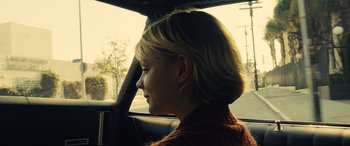 Movie still from “Drive” (2011), directed by Nicolas Winding Refn – A woman sitting in the driver's seat of a car; Close Up shot, Over the shoulder angle