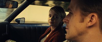 Movie still from “Drive” (2011), directed by Nicolas Winding Refn – A man and a woman sitting in the back of a car; Close Up shot, Over the shoulder angle