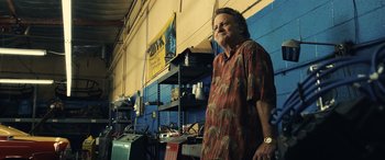 Movie still from “Drive” (2011), directed by Nicolas Winding Refn – An older man standing in front of a garage; Medium shot, Low angle