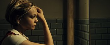 Movie still from “Drive” (2011), directed by Nicolas Winding Refn – A young woman is looking at her reflection in the mirror; Close Up shot, Over the shoulder angle