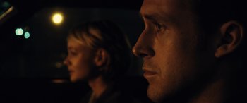 Movie still from “Drive” (2011), directed by Nicolas Winding Refn – A man and a woman looking into the distance; Close Up shot, Over the shoulder angle