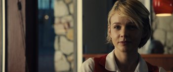 Movie still from “Drive” (2011), directed by Nicolas Winding Refn – A person with short blonde hair; Close Up shot, Over the shoulder angle