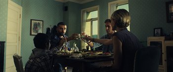 Movie still from “Drive” (2011), directed by Nicolas Winding Refn – A group of people sitting at a table with drinks; Medium shot, Low angle