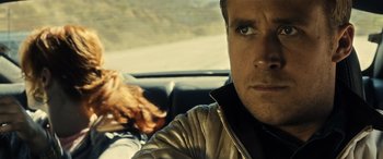 Movie still from “Drive” (2011), directed by Nicolas Winding Refn – A person in a car on the side of the road; Close Up shot, Over the shoulder angle