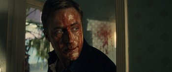 Movie still from “Drive” (2011), directed by Nicolas Winding Refn – A person with blood all over his face; Close Up shot, Low angle