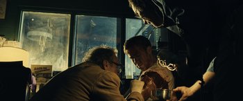 Movie still from “Drive” (2011), directed by Nicolas Winding Refn – A group of people sitting around a table; Medium shot, Low angle