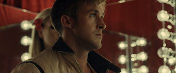 Movie still from “Drive” (2011), directed by Nicolas Winding Refn – A person wearing a jacket looking to the side; Close Up shot, Low angle