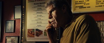Movie still from “Drive” (2011), directed by Nicolas Winding Refn – A man talking on a phone in front of a menu; Close Up shot, Low angle
