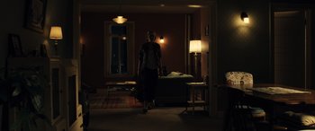 Movie still from “Drive” (2011), directed by Nicolas Winding Refn – A person standing in a dark room with a lamp; Wide shot, Low angle