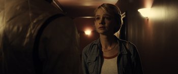 Movie still from “Drive” (2011), directed by Nicolas Winding Refn – A woman standing in front of a mirror in a room; Close Up shot, Over the shoulder angle