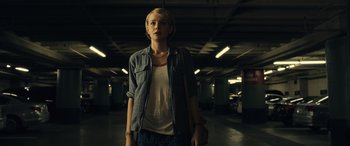 Movie still from “Drive” (2011), directed by Nicolas Winding Refn – A woman standing in a parking garage holding a purse; Medium shot, Low angle