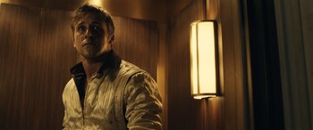 Movie still from “Drive” (2011), directed by Nicolas Winding Refn – A man standing in front of a light in a room; Close Up shot, Low angle