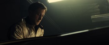 Movie still from “Drive” (2011), directed by Nicolas Winding Refn – A man sitting in front of a piano in a darkened room; Close Up shot, Low angle