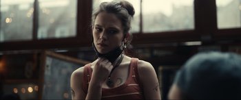 Movie still from “Dumb Money” (2023), directed by Craig Gillespie – A woman with a tattoo on her neck and shoulder; Close Up shot, Low angle