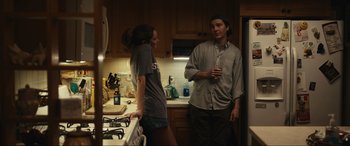 Movie still from “Dumb Money” (2023), directed by Craig Gillespie – A man and a woman standing in a kitchen talking; Medium shot, Over the shoulder angle
