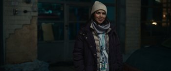 Movie still from “Dumb Money” (2023), directed by Craig Gillespie – A woman wearing a winter coat and a hat; Medium shot, Over the shoulder angle