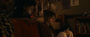 Movie still from “Dumb Money” (2023), directed by Craig Gillespie – A woman sitting on a couch next to another woman; Medium shot, Low angle
