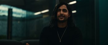 Movie still from “Dumb Money” (2023), directed by Craig Gillespie – A man with long black hair and a beard; Close Up shot, Over the shoulder angle