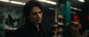 Movie still from “Dumb Money” (2023), directed by Craig Gillespie – A person wearing a suit and tie; Close Up shot, Over the shoulder angle