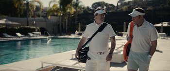 Movie still from “Dumb Money” (2023), directed by Craig Gillespie – A man wearing a visor and holding a tennis racket; Medium shot, Low angle