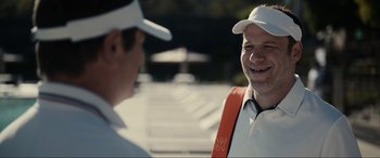 Movie still from “Dumb Money” (2023), directed by Craig Gillespie – A man wearing a white shirt and orange vest talking to another man wearing an orange vest; Close Up shot, Over the shoulder angle