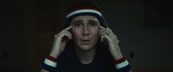 Movie still from “Dumb Money” (2023), directed by Craig Gillespie – A man with a headband is holding his hands up to his ears; Close Up shot, Low angle