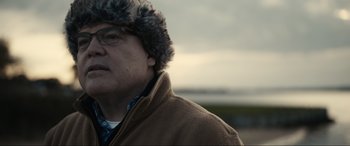 Movie still from “Dumb Money” (2023), directed by Craig Gillespie – A person wearing a jacket and a fur hat; Close Up shot, Over the shoulder angle