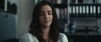 Movie still from “Dumb Money” (2023), directed by Craig Gillespie – A beautiful young lady sitting in front of a book shelf; Close Up shot, Over the shoulder angle
