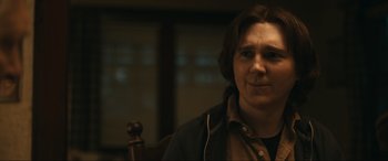 Movie still from “Dumb Money” (2023), directed by Craig Gillespie – A man with a brown shirt is sitting in a chair; Close Up shot, Over the shoulder angle