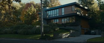 Movie still from “Dumb Money” (2023), directed by Craig Gillespie – A house that is on the side of a hill; Extreme Wide shot, Low angle