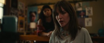 Movie still from “Dumb Money” (2023), directed by Craig Gillespie – A woman with a necklace is sitting in front of another woman; Close Up shot, Over the shoulder angle