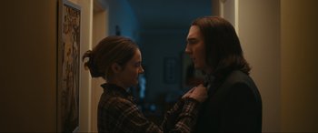 Movie still from “Dumb Money” (2023), directed by Craig Gillespie – A man and a woman standing next to each other in a room; Medium shot, Over the shoulder angle