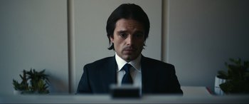 Movie still from “Dumb Money” (2023), directed by Craig Gillespie – A man wearing a suit and tie in front of a mirror; Close Up shot, Over the shoulder angle