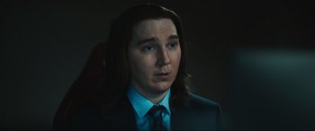Movie still from “Dumb Money” (2023), directed by Craig Gillespie – A man with long hair wearing a suit and tie; Close Up shot, Over the shoulder angle