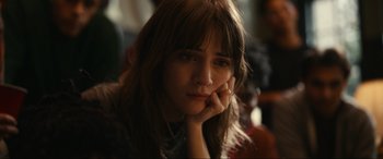 Movie still from “Dumb Money” (2023), directed by Craig Gillespie – A woman sitting in front of a window with her hand on her chin; Close Up shot, Over the shoulder angle