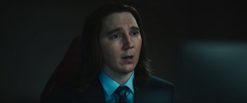 Movie still from “Dumb Money” (2023), directed by Craig Gillespie – A man with long hair wearing a suit and tie; Close Up shot, Over the shoulder angle