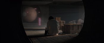 Movie still from “Dune” (2021), directed by Denis Villeneuve – A person sitting on the ground in a dark room; Wide shot, High angle