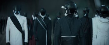 Movie still from “Dune” (2021), directed by Denis Villeneuve – A group of people in black suits and white horns; Medium shot, Over the shoulder angle