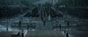 Movie still from “Dune” (2021), directed by Denis Villeneuve – A group of people standing on some steps in front of a forest; Extreme Wide shot, High angle