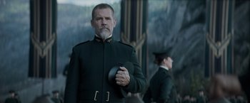 Movie still from “Dune” (2021), directed by Denis Villeneuve – A man in a military uniform holding a hat; Medium shot, Over the shoulder angle