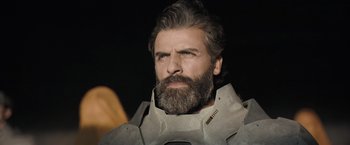 Movie still from “Dune” (2021), directed by Denis Villeneuve – A man with long hair and a beard wearing a helmet; Close Up shot, Low angle