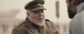 Movie still from “Dune” (2021), directed by Denis Villeneuve – An older man wearing a military uniform and a hat; Close Up shot, High angle