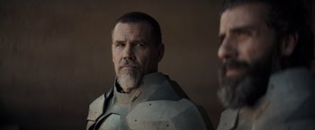 Movie still from “Dune” (2021), directed by Denis Villeneuve – A person with a beard wearing armor; Close Up shot, Over the shoulder angle