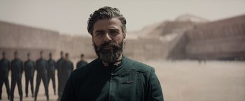 Movie still from “Dune” (2021), directed by Denis Villeneuve – A man with a long beard and a green jacket; Close Up shot, Over the shoulder angle