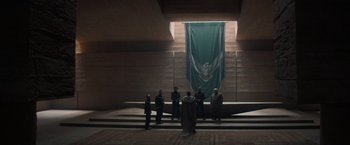 Movie still from “Dune” (2021), directed by Denis Villeneuve – A group of men standing in front of a green banner; Extreme Wide shot, High angle