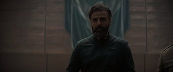 Movie still from “Dune” (2021), directed by Denis Villeneuve – A man with long hair and a goatee is standing; Close Up shot, Low angle