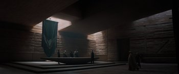 Movie still from “Dune” (2021), directed by Denis Villeneuve – A group of people standing in a room with a boat; Extreme Wide shot, Low angle