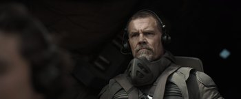 Movie still from “Dune” (2021), directed by Denis Villeneuve – A man with headphones on looking into the distance; Close Up shot, Over the shoulder angle